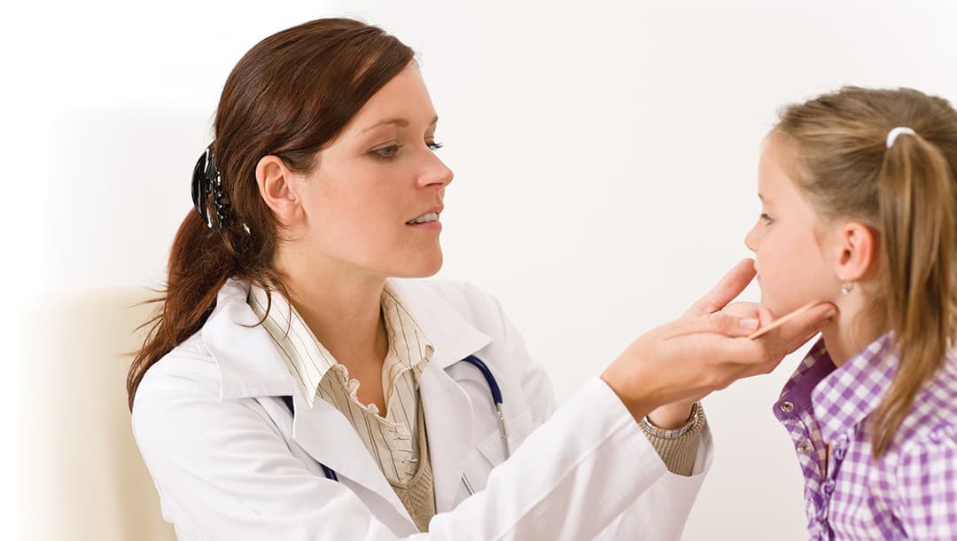 photo of Female doctor examining child