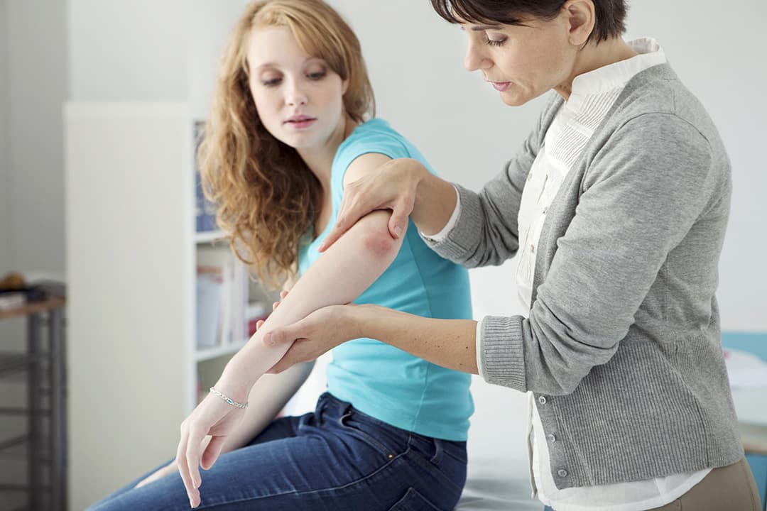 photo of mom and daughter inspecting a rash on the daughters elbow