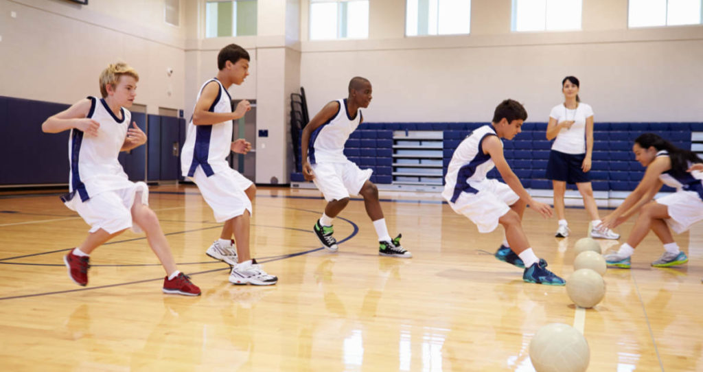 Photo of High School Students Playing Dodge Ball In Gym.