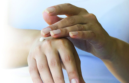 Photo of woman applying lotion to her hand