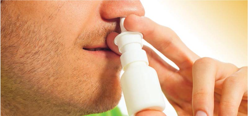 Image of a man using a nasal spray properly