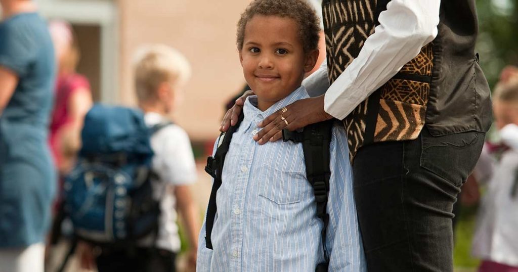 Tween boy with smile and backpack looking at the camera