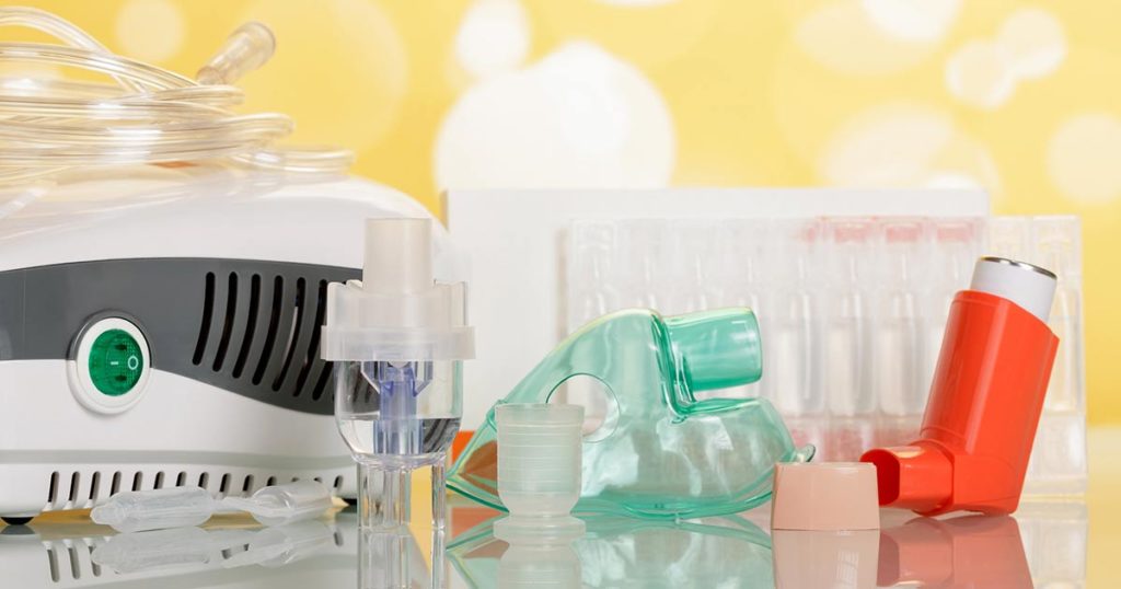 Various asthma medications on a counter with a yellow background. There