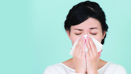 photo of a woman blowing her nose