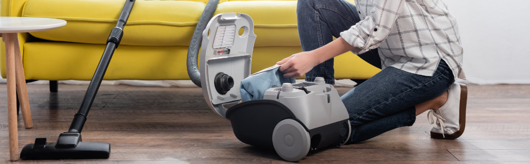 Woman changing hepa filter in her vacuum cleaner.