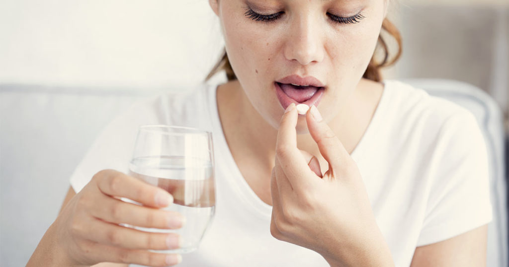 Young woman taking an aspirin substitute because she has AERD