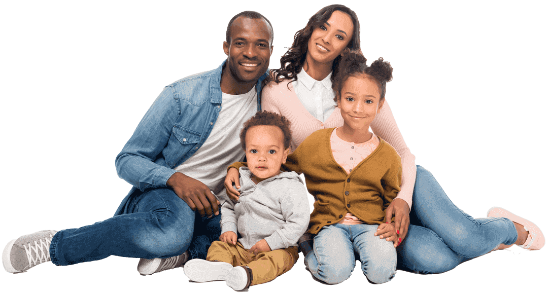 Multi-racial family of four sitting on the ground smiling at the camera.