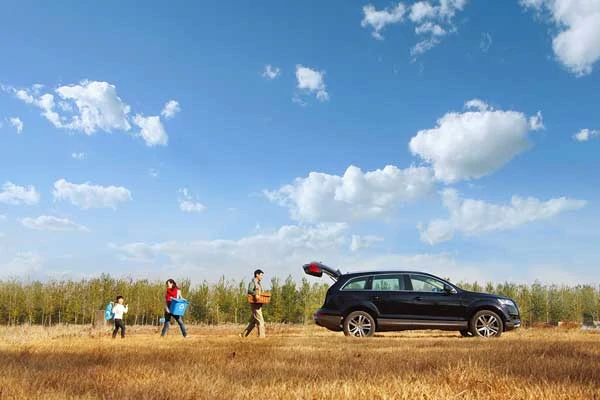 Family packing car after having a lovely picnic in the park during a beautiful autumn day.