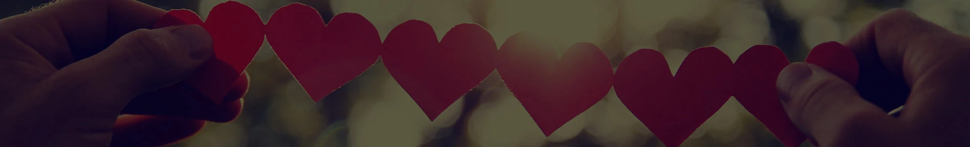 Background image of person holding up string of paper hearts
