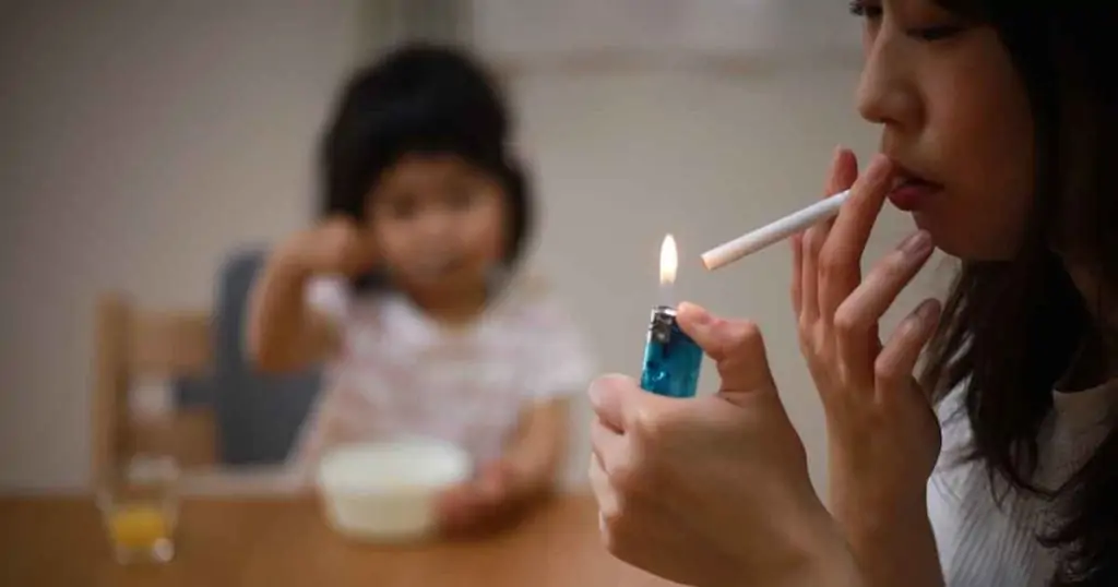 Photo of mom smoking in front of her child