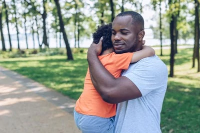 Serious man holding his child in the park